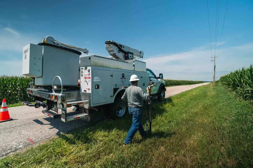 A Tipmont lineman next to a bucket truck