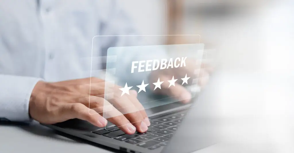 A man typing on a laptop with the word feedback displayed along with 5 stars